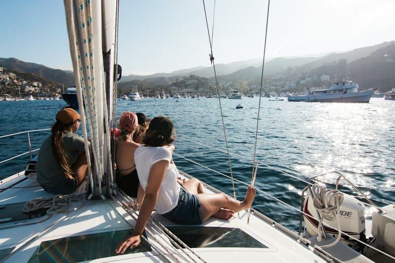 Amigos aproveitando um passeio de veleiro no mar